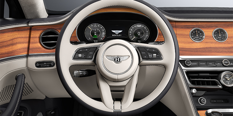 Gohm Sportwagen GmbH | Bentley Singen New Bentley Flying Spur sedan steering wheel and dash in Linen and Imperial Blue hides and Open Pore Koa veneer